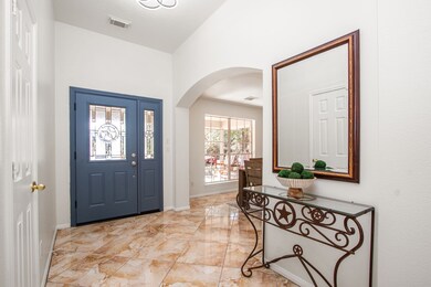 Bright and welcoming entryway with updated blue front door featuring beveled glass panels.