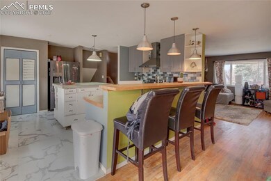 Kitchen featuring light countertops, wall chimney 