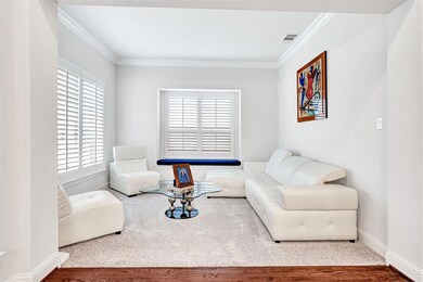 A sweet formal living room flanks the other side of the foyer from the dining room and offers a quiet place to sit and read, play card games, or visit with friends and family.  Plantation shutters and crown molding perfectly accents the neutral paint