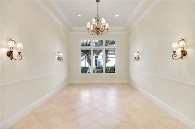 Large living room with chandelier, wall sconces, impressive moldings, and tray ceiling