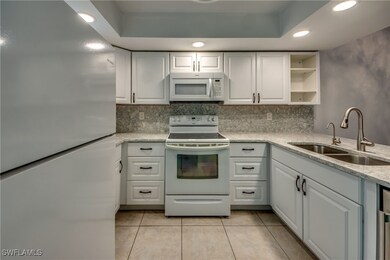 Kitchen featuring white appliances, a sink, light