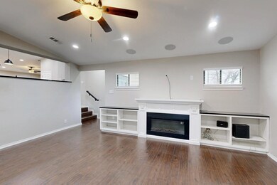 Unfurnished living room with ceiling fan and hardw