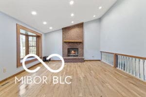 interior space with wood finished floors, baseboards, a fireplace, recessed lighting, and vaulted ceiling