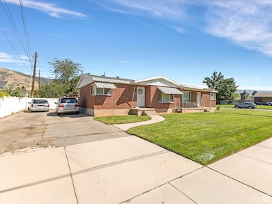 Duplex exterior with brick siding, driveway, and a front lawn