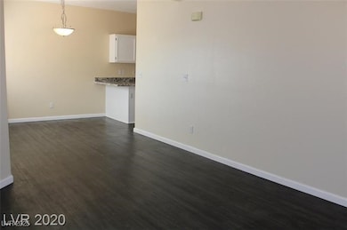 Unfurnished living room with baseboards and dark w