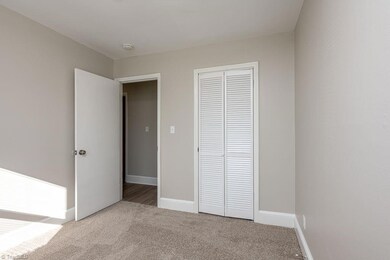 Bedroom 3: Features include new carpet flooring to help keep your feet warm on cool mornings, fresh new paint and a window for natural lighting with blinds for privacy. The closet with bifold doors is to the right side and the entry door is to the left side.