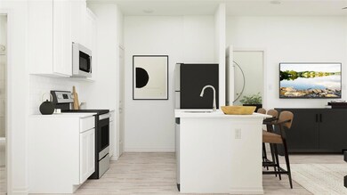 Kitchen featuring an island with sink, appliances 