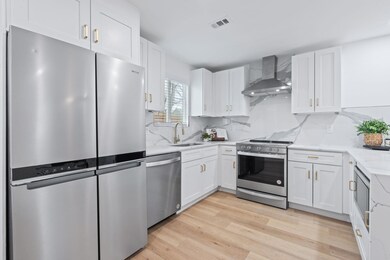 Kitchen featuring light stone countertops, wall c