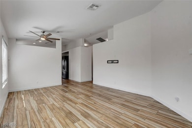 Spare room with wood finish floors and a ceiling fan