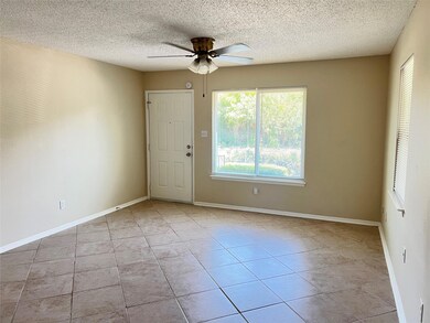 Spare room featuring light tile patterned floors, a textured ceiling, and ceiling fan