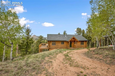 Log cabin with driveway, log exterior, a shingled roof, and a deck