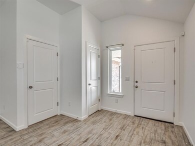Entryway with light wood-style floors and vaulted ceiling