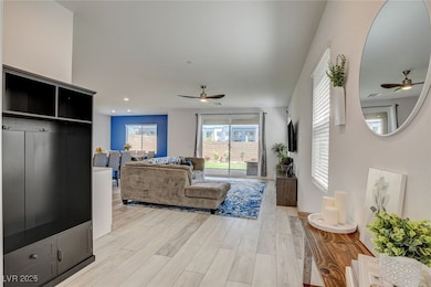 Living room featuring ceiling fan and light vinyl-