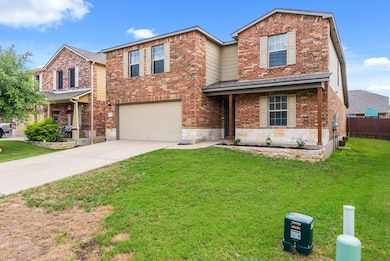 Traditional home with a garage, driveway, and bri