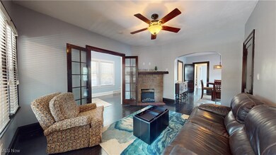 Living room with a fireplace, dark hardwood / wood-style floors, and ceiling fan