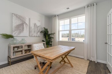Office space featuring baseboards, visible vents, 