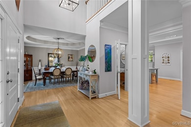 Foyer entrance featuring a chandelier, light wood-