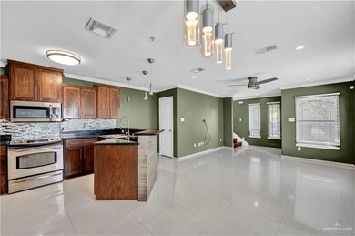 Kitchen featuring a sink, dark countertops, visible vents, decorative backsplash, and appliances with stainless steel finishes