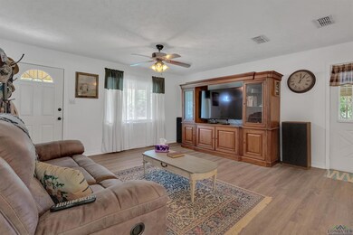 Living area featuring light wood-style flooring, baseboards, and ceiling fan