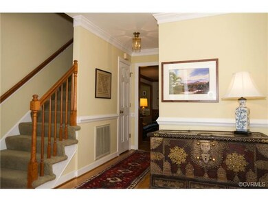 The foyer has hardwood floors, crown molding and chair rail, a staircase to the second floor, powder room, coat closet and access to the garage.