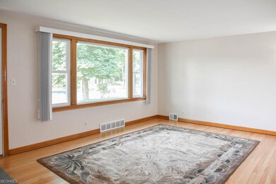 Living room with a picture window and hardwood flooring.