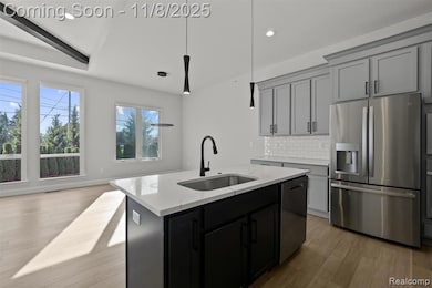 Kitchen with stainless steel appliances, decorative backsplash, light wood-style flooring, decorative light fixtures, and recessed lighting