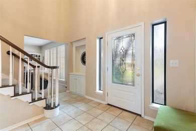 Foyer entrance with baseboards, a towering ceiling