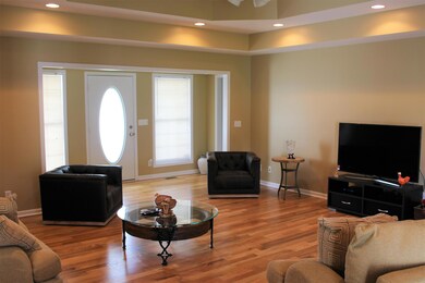 Spacious living area features hardwood floors, trey ceiling, access to both the front porch and back deck, and recessed lighting.