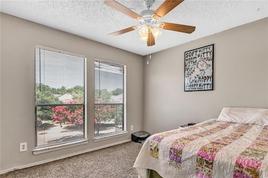 Bedroom with a textured ceiling, a ceiling fan, an