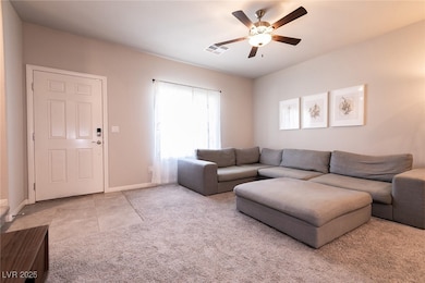 Carpeted living room with a ceiling fan and front