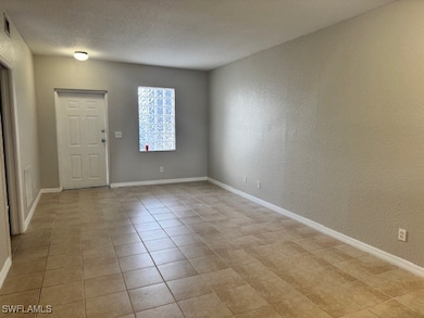 Unfurnished room with baseboards, a textured wall,