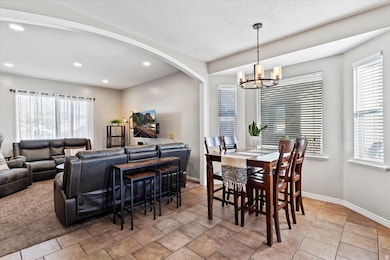 Dining room with arched walkways, recessed lighting, and a chandelier
