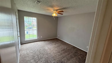 Carpeted spare room with visible vents, baseboards