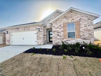 Ranch-style house featuring concrete driveway, bri