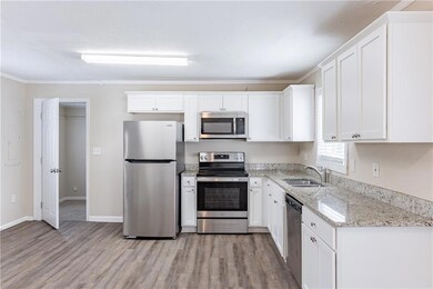 Kitchen with sink, white cabinetry, stainless stee