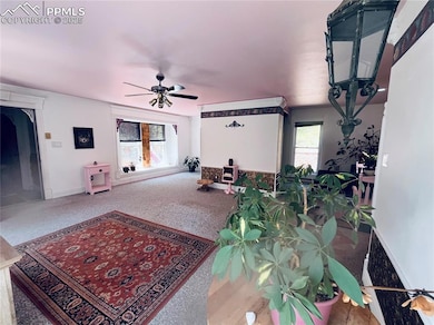 Living area with ceiling fan and carpet floors