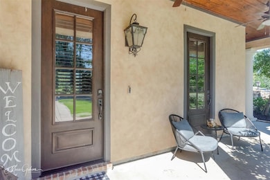 Property entrance with ceiling fan and a porch