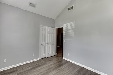 Unfurnished room featuring high vaulted ceiling and wood finished floors