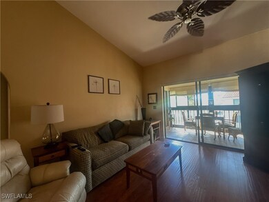 Living area featuring a ceiling fan, high vaulted