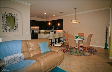 Living area featuring crown molding, recessed lighting, and light tile patterned flooring
