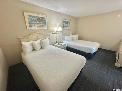 Carpeted bedroom featuring a textured ceiling