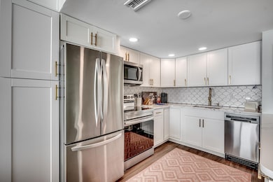 Sleek kitchen featuring quartz counters and eye-catching tile backsplash