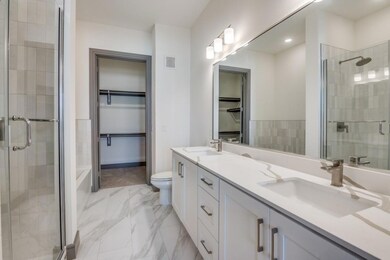 Bathroom featuring vanity, toilet, and an enclosed