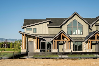 View of front of home with a standing seam roof, stone siding, a mountain view, a shingled roof, and a metal roof
