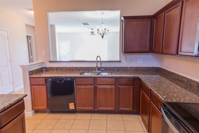 This kitchen features granite countertops, dark wo