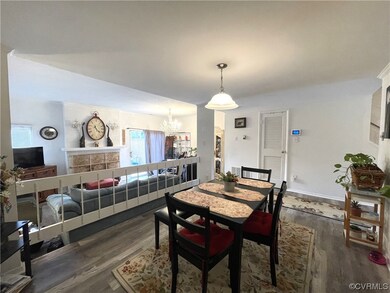 Dining room with a chandelier and dark hardwood /
