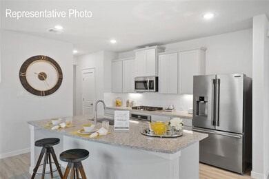 Kitchen with light stone countertops, light hardwood / wood-style floors, a kitchen island with sink, and appliances with stainless steel finishes