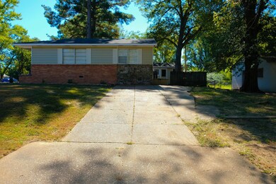 Side of home has driveway with entrance to the den