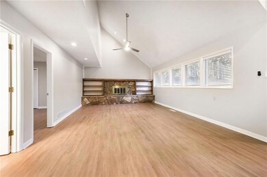 Unfurnished living room with ceiling fan, a stone 