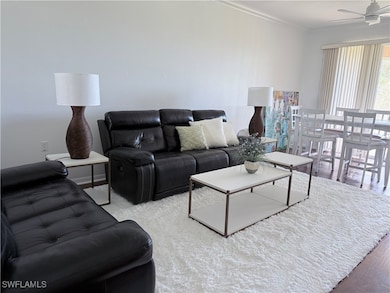 Living area with wood finished floors, crown molding, and a ceiling fan